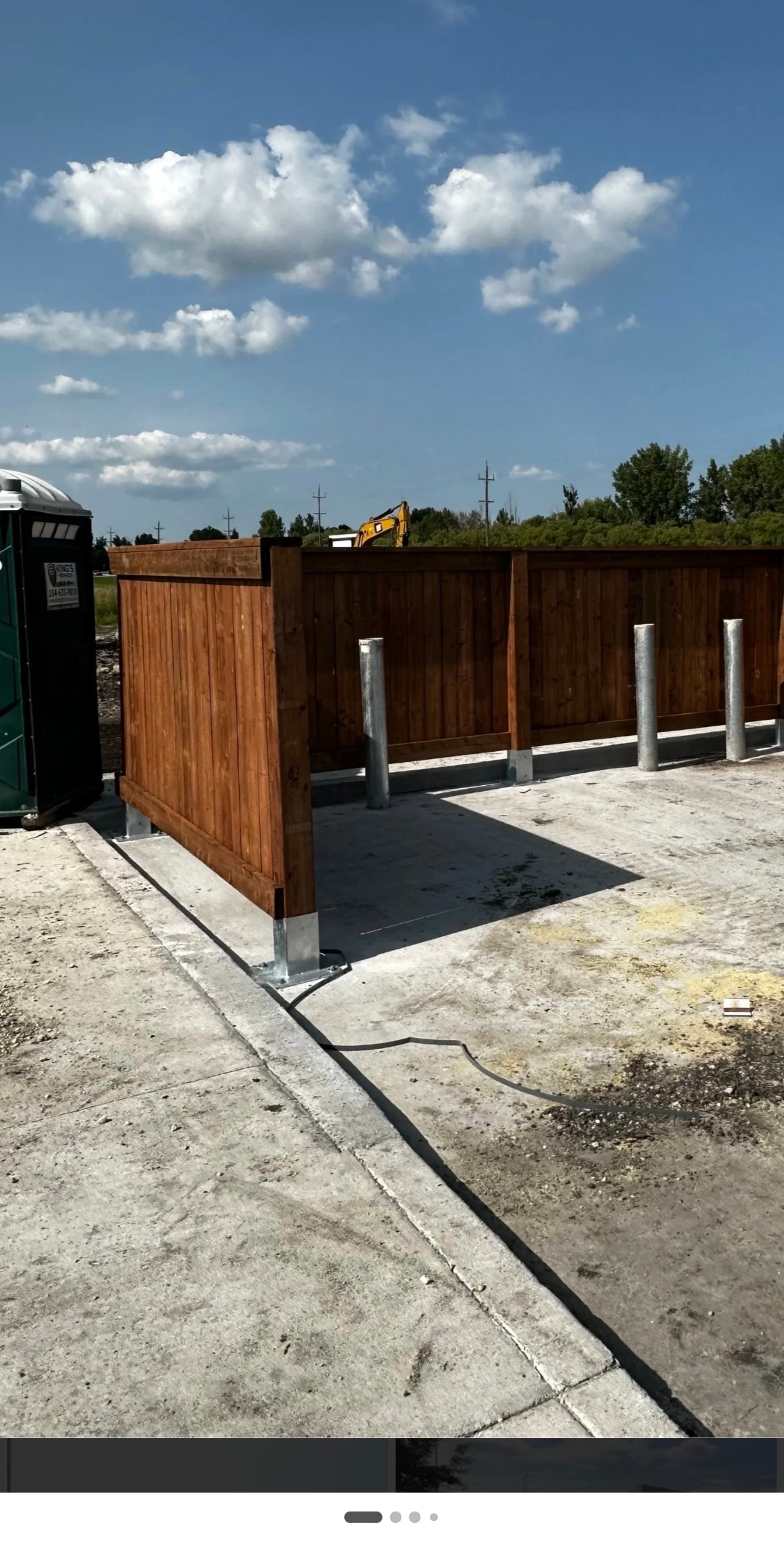 Commercial Wood Privacy Fence with Steel Bollards — Concrete Pad Installation