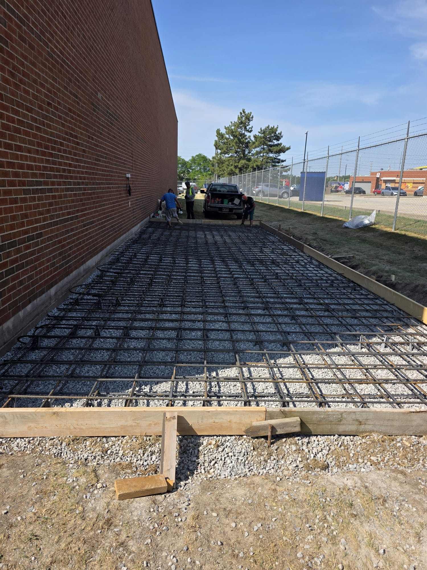 Large Concrete Pad Prep — Full Rebar Grid, Commercial Brick Building
