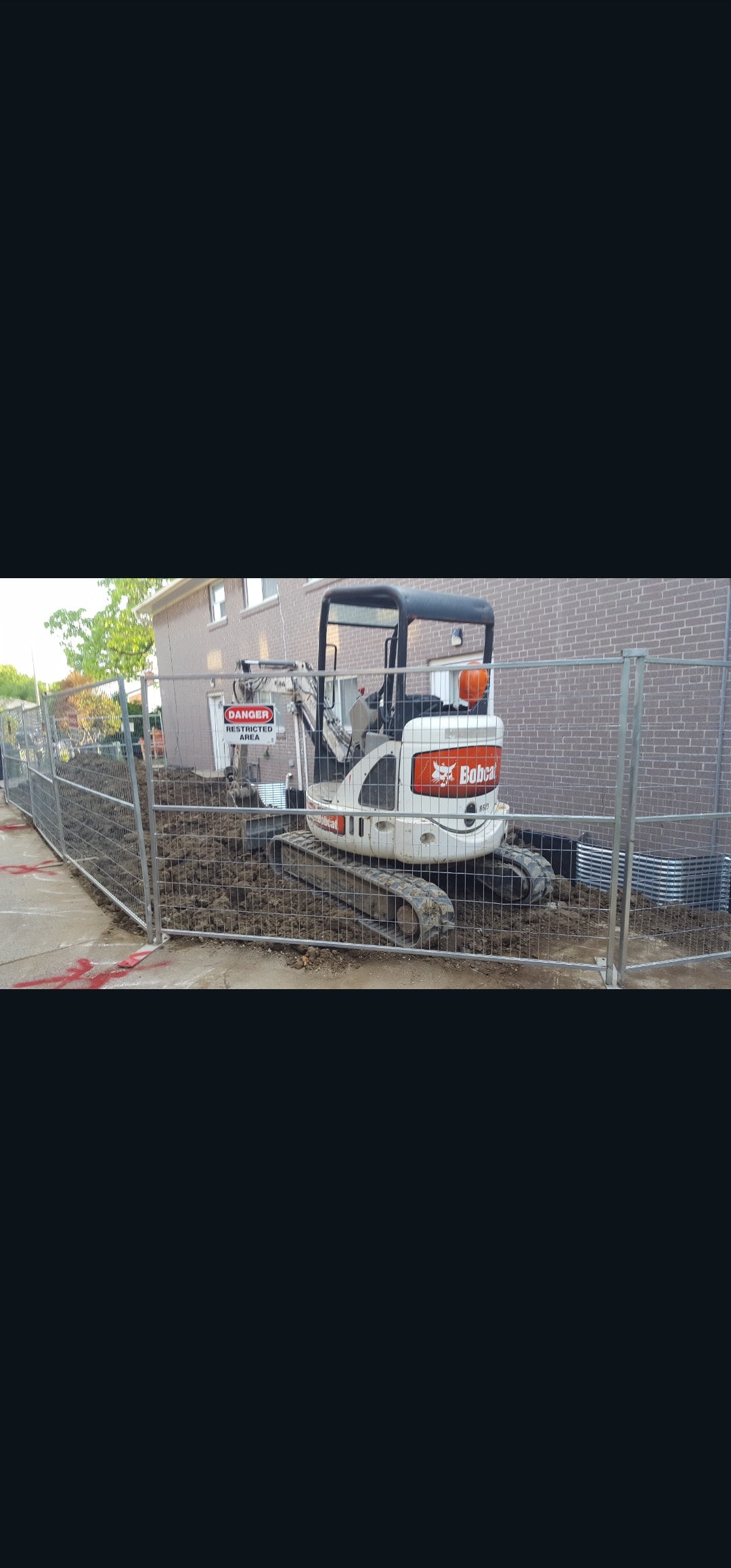 Excavation Site — Bobcat Behind Safety Fence, Danger Restricted Area