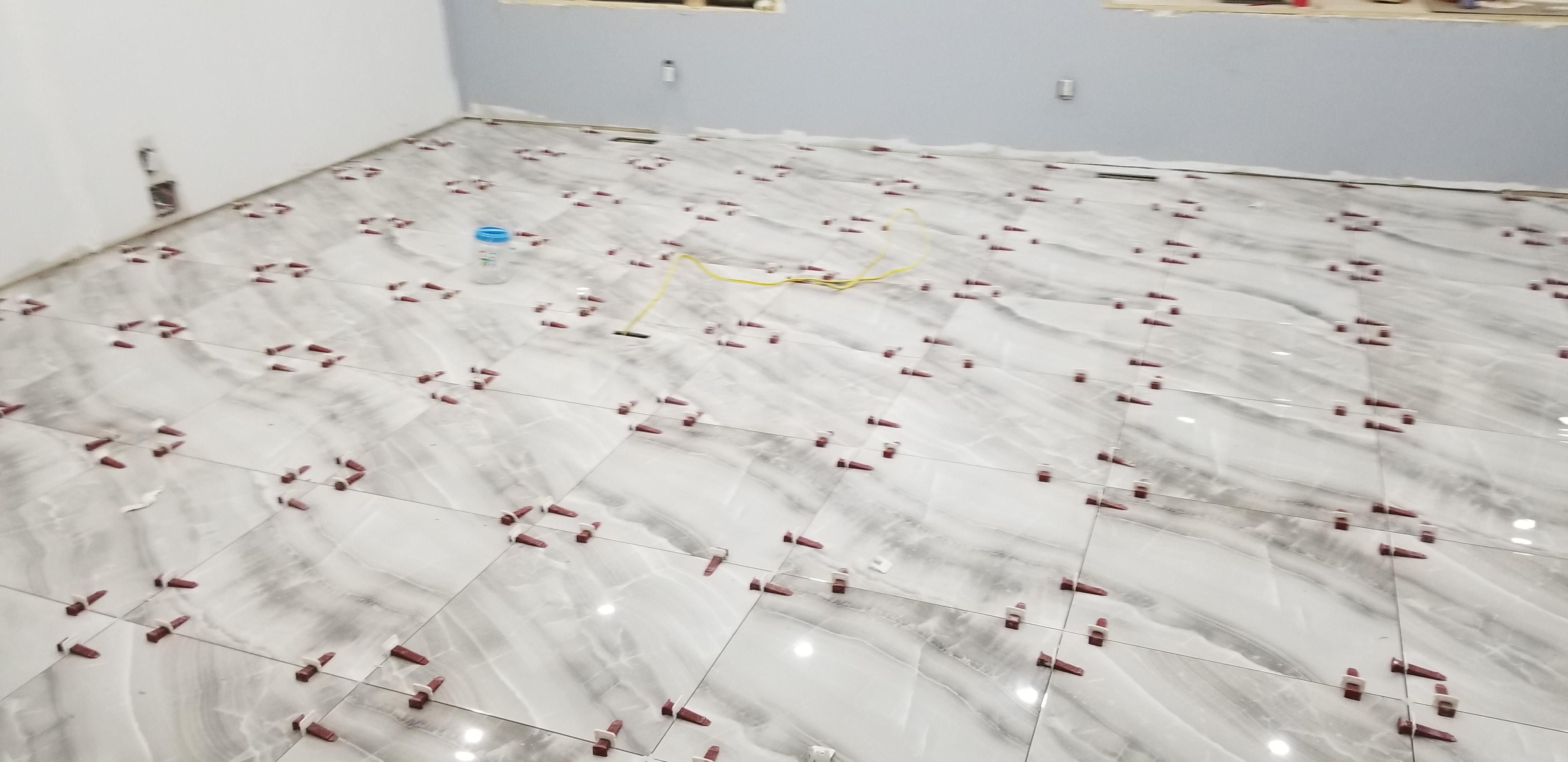 Marble Tile Floor Installation with Leveling Spacers — Commercial Unit