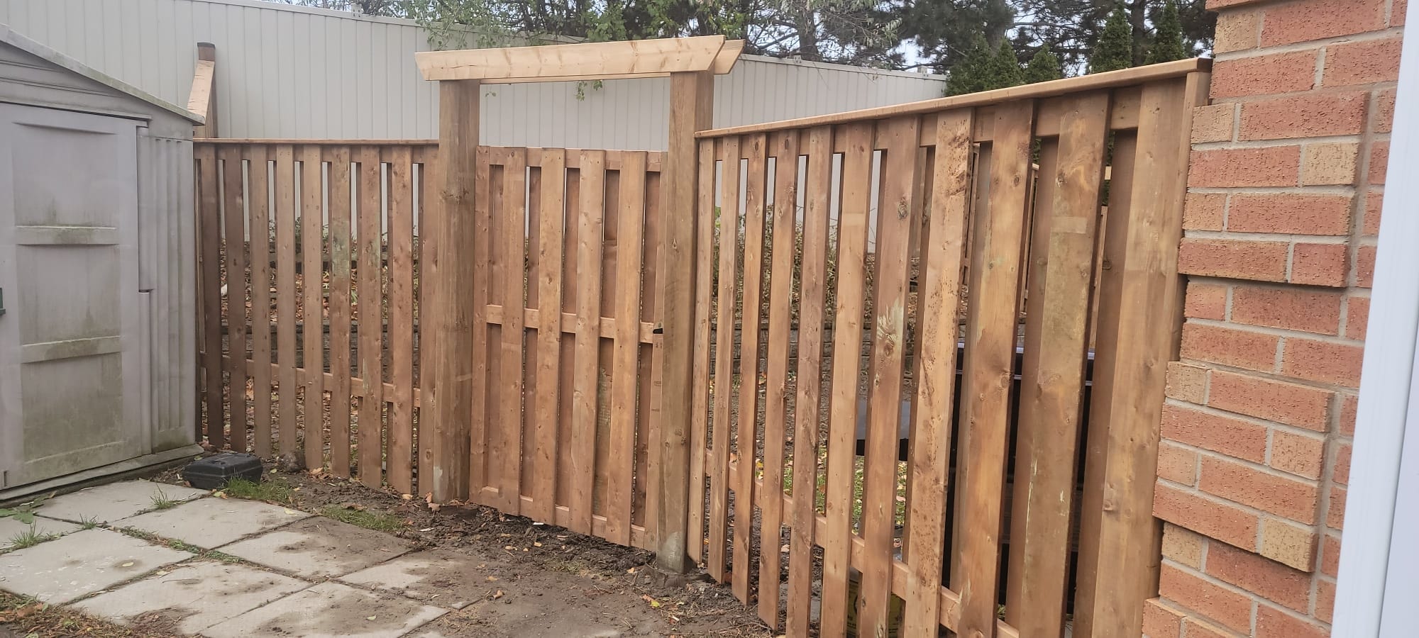 Wood Fence with Pergola Gate — Commercial Housing Unit, Brick Building